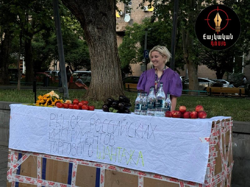 Активисты на Вернисаже в Ереване у импровизированного прилавка с помидорами, баклажанами, цветами и бутылками «Джермука»